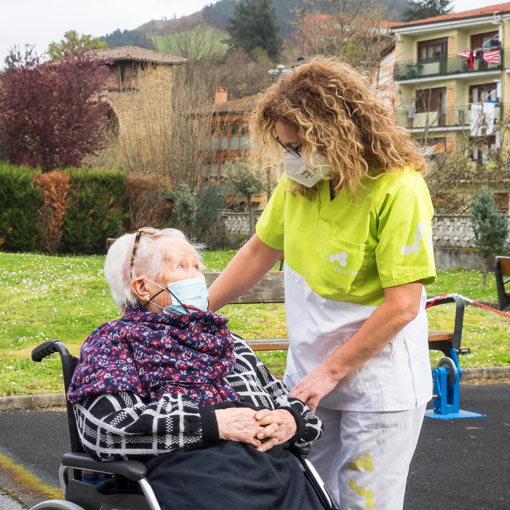 Una trabajadora y una residente conversan a las afuera de la residencia de mayores